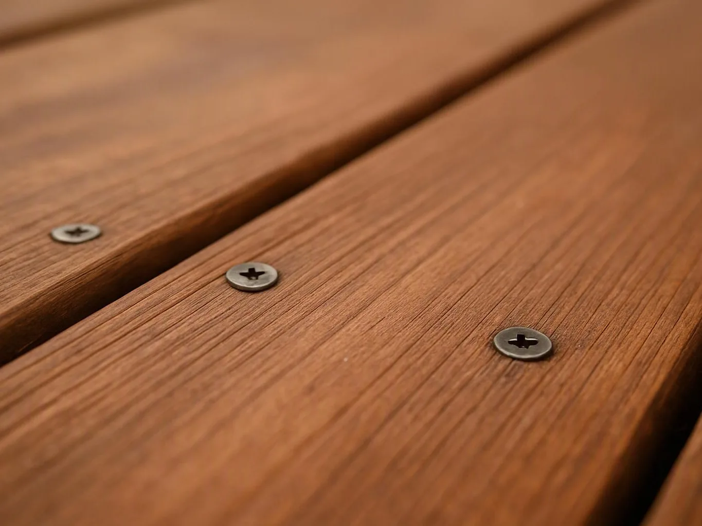 Close-up of weathered wooden boards joined by metal screws, filling the frame